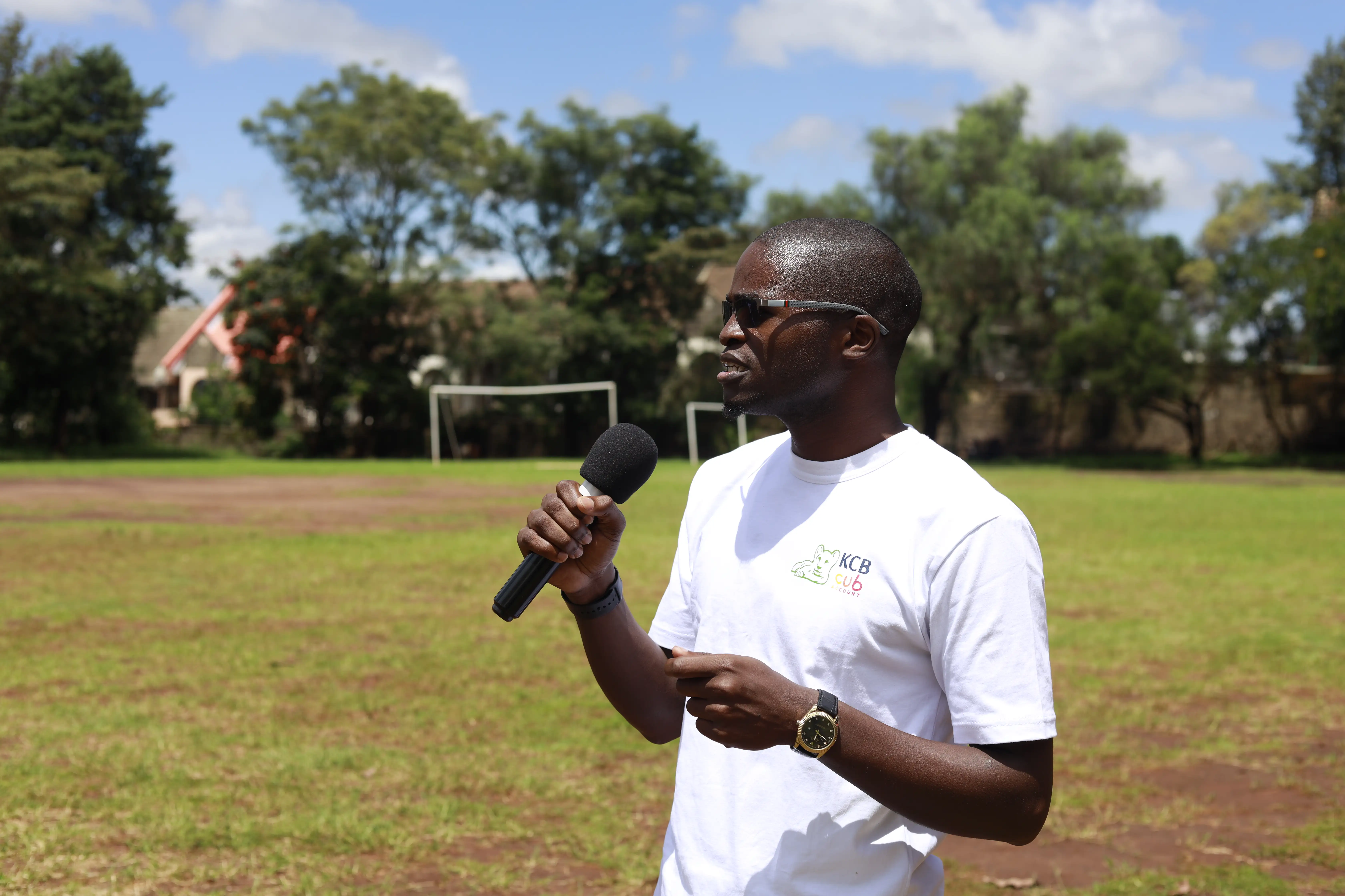Woman speaking into a microphone at an outdoor corporate event
